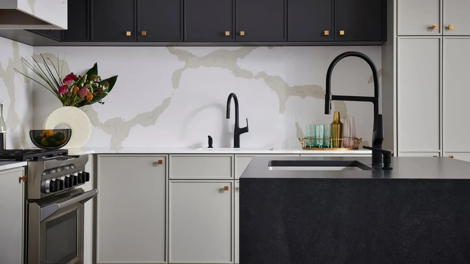 Modern kitchen with a black curved faucet, light gray cabinets, and a dark island countertop.