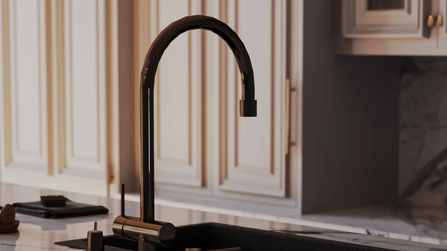 Modern high-arc black faucet with gold accents over a white countertop in a kitchen.